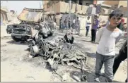  ?? Picture: REUTERS ?? CARNAGE: Residents gather at the site of a car bomb attack in the Kamaliya district in Baghdad yesterday.