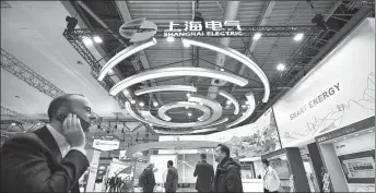  ?? REN PENGFEI / XINHUA ?? People walk past the booth of Shanghai Electric at Hannover Messe 2024 held from April 22 to 26 in Hannover, Germany.