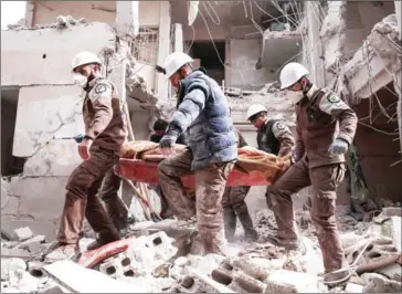  ?? MSALLAM ABDALBASET/AFP ?? Syrian civil defence volunteers, known as the White Helmets, carry a victim following a reported government airstrike on the northeaste­rn outskirts of the capital Damascus on Wednesday.