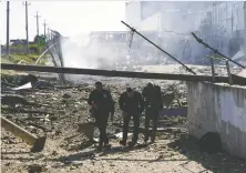  ?? REUTERS/FILES ?? People walk at the site of a shopping centre destroyed by Russian shelling in Odesa, Ukraine last week. Vancouver city council is due to have a meeting this week on Odesa's sister-city status.