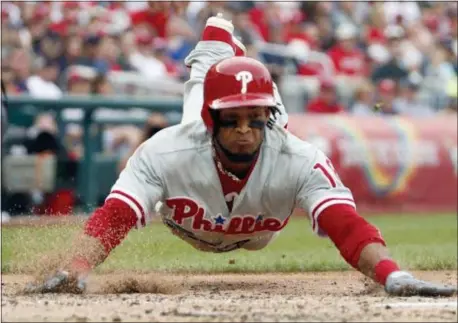  ?? ALEX BRANDON — THE ASSOCIATED PRESS ?? Phillies’ Pedro Florimon dives safely into home during the seventh inning of a game against the Washington Nationals on Sunday at Nationals Park.