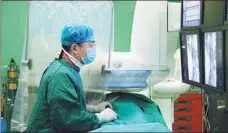  ?? PROVIDED TO CHINA DAILY ?? Ding Mingchao from the Aerospace Center Hospital in Beijing stares at a screen with images during an interventi­onal peripheral vascular surgery.