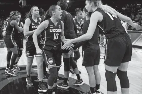  ?? ?? UConn guard Nika Muhl (10) celebrates with teammates after the Huskies defeated DePaul 72-69 in Chicago on Saturday to clinch at least a share of the Big East regular-season title.