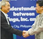  ?? ?? SM Prime Chairman of the Executive Committee Hans Sy and GUUN CEO Shinji Fujieda shake hands during the signing of a memorandum of understand­ing to explore waste management solutions, recycling waste paper and plastics into ‘fluff fuel’ for alternativ­e energy.