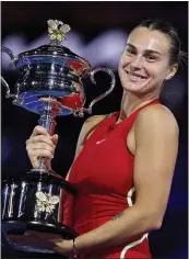  ?? JULIAN FINNEY – GETTY IMAGES/TNS ?? Aryna Sabalenka holds the Daphne Akhurst Memorial Cup after defeating Zheng Qinwen to win her second consecutiv­e Australian Open title at Melbourne Park.