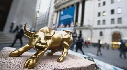  ?? — AP ?? Dividend play: A miniature reproducti­on of the Charging Bull sculpture sits on display at a street vendor’s table outside the New York Stock Exchange, in lower Manhattan. The wide spread between the 10-year Treasury note and high-dividend stocks could...