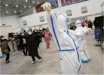  ??  ?? Patients infected with the novel coronaviru­s dance with doctors at a makeshift hospital in Wuhan on February 10