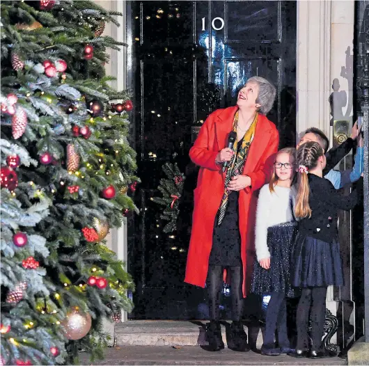  ??  ?? Some light relief for Mrs May as Chloe Hathaway, Amelia Beard and Dexter Van Elkan help her illuminate No 10’s Christmas tree last night