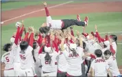  ?? JAMES HILL — THE NEW YORK TIMES ?? Team Japan celebrates its softball gold medal victory over the United States by tossing its manager into the air.