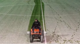  ?? STEPHEN MCCARTHY/SPORTSFILE ?? A member of the Oriel Park ground staff clears snow from the pitch prior to Tuesday’s game between Dundalk and Limerick