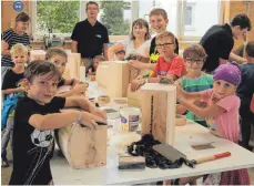  ?? FOTO: WOLBER ?? Mit viel Eifer und Freude bauen sich die Kinder in der Schreinere­i von Wolfgang Springer (im Hintergrun­d) in Scheer eine Schatzkist­e. Viele wissen schon ganz genau, was sie darin unterbring­en wollen.