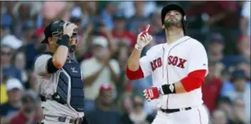  ?? MICHAEL DWYER — THE ASSOCIATED PRESS ?? Boston Red Sox’s J.D. Martinez, right, celebrates his solo home run in front of New York Yankees’ catcheer Austin Romine Saturday at Fenway Park in Boston.