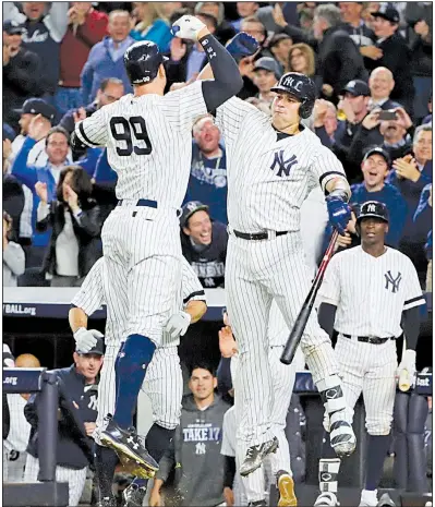  ?? AP/FRANK FRANKLIN II ?? Aaron Judge (99) and Gary Sanchez of the New York Yankees celebrate after Judge’s two-run home run in the fourth inning of the Yankees’ 8-4 victory over the Minnesota Twins in Tuesday night’s American League wild-card game at Yankee Stadium. The...