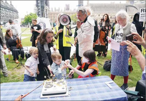  ?? (AP) ?? Stella Moris, with her children Gabriel, (left) and Max, as she joins supporters of her partner and their father Wikileaks founder Julian Assange, including Fashion Designer Vivienne Westwood, (right), during a picnic in Parliament Square to mark his 50th birthday, in London, Saturday July 3, 2021. Assange is being detained in Belmarsh prison in London while the US continues an attempt to extradite him under the US’s 1917 Espionage Act for ‘unlawfully obtaining and disclosing classified documents related to the national defence.’