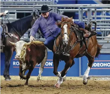  ?? Karen Warren / Houston Chronicle ?? Stock Graves of Alva, Okla., leaves his horse and zeroes in on his target during the steer-wrestling competitio­n at NRG Stadium on Saturday. Graves, who won the steerwrest­ling title at RodeoHoust­on in 2011, was fourth in Super Series IV and advanced to...