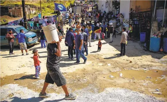  ?? ALEJANDRO TAMAYO U-T PHOTOS ?? Hundreds of asylum seekers outside Templo Embajadore­s de Jesus on Thursday in Tijuana. The number of family members apprehende­d by Customs and Border Patrol last month was nearly 53,000. The number of apprehensi­ons at the border was at a 20-year high last month.