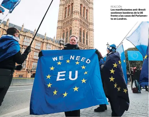  ??  ?? REACCIÓNLo­s manifestan­tes anti-brexit sostienen banderas de la UE frente a las casas del Parlamento en Londres.