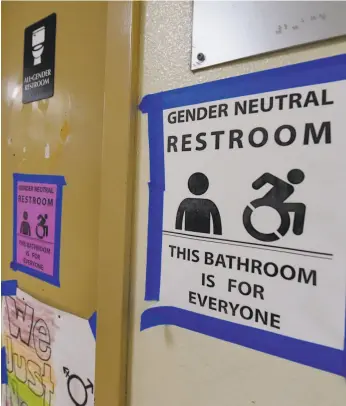  ?? Mark Ralston / AFP / Getty Images 2016 ?? Signs are posted outside the Santee High School’s gender-neutral restrooms at its campus in Los Angeles, in conformanc­e with California law.
