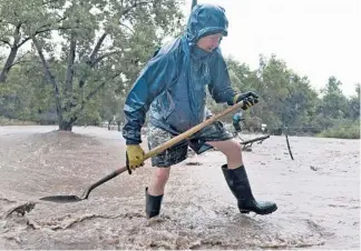  ?? | JEREMY PAPASSO/AP ?? Dean Beacom works to save his home from a flash flood in Boulder, Colo., on Sunday.