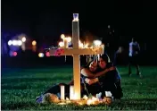  ?? ASSOCIATED PRESS ?? TWO PEOPLE COMFORT each other as they sit and mourn at one of seventeen crosses, after a candleligh­t vigil for the victims of the Wednesday shooting at Marjory Stoneman Douglas High School, in Parkland, Fla., Thursday. 10. Newly-Created v. Establishe­d...