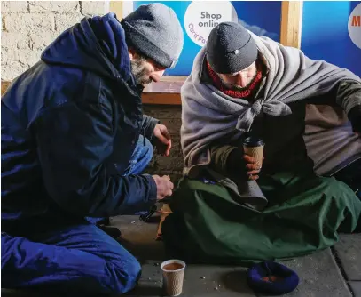  ??  ?? Life on the street: Dan Bennet, left, with another beggar in Ely, Cambridges­hire yesterday