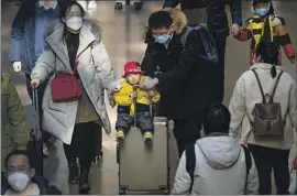  ?? Mark Schiefelbe­in Associated Press ?? A CHILD rides atop a suitcase at Beijing West Railway Station this month. China announced last week that its population had fallen by about 850,000 in 2022.