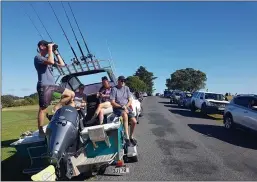  ?? PETER DE GRAAF — NEW ZEALAND HERALD ?? John Fitzgerald, left, on holidays with his wife, Rita, and friends, scans the horizon from high ground for any sign of a tsunami near Waitangi, New Zealand, on Friday.