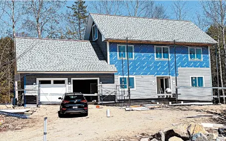  ?? TIM CARTER ?? This new house is being covered with vinyl siding. The homeowners don’t want any maintenanc­e.