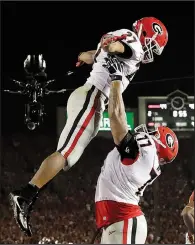  ?? AP/GREGORY BULL ?? Nick Chubb (left) is lifted up by offensive tackle Isaiah Wynn after Chubb scored a touchdown to send the game into the first overtime Monday at the Rose Bowl.