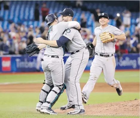  ?? TOM SZCZERBOWS­KI/GETTY IMAGES ?? Seattle Mariners pitcher James Paxton gets a hug from catcher Mike Zunino after recording a 99-pitch no-hitter against the Blue Jays on Tuesday at the Rogers Centre in Toronto, becoming only the second Canadian to achieve the feat and first to do it in...