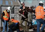  ?? (AP/Ashley Landis) ?? California Gov. Gavin Newsom removes cardboard from a Union Pacific railroad site Thursday in Los Angeles.