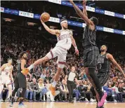  ?? Christian Petersen/TNS ?? Devin Booker of the Suns makes a leaping pass around Dariq Whitehead of the Nets during the first half at Footprint Center on Wednesday in Phoenix.