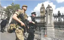  ?? THE ASSOCIATED PRESS ?? A member of the army joins police officers Wednesday in Westminste­r, London. Britons will find armed troops at vital locations after the official threat level was raised to its highest point following Monday’s suicide bombing that killed 22.