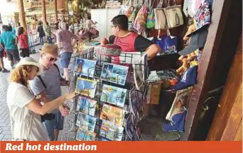  ?? Photo: Pankaj Sharma/Gulf News ?? Tourists select postcards at Deira Old Souq yesterday. The area continues to be a magnet for tourists even in the summer months.