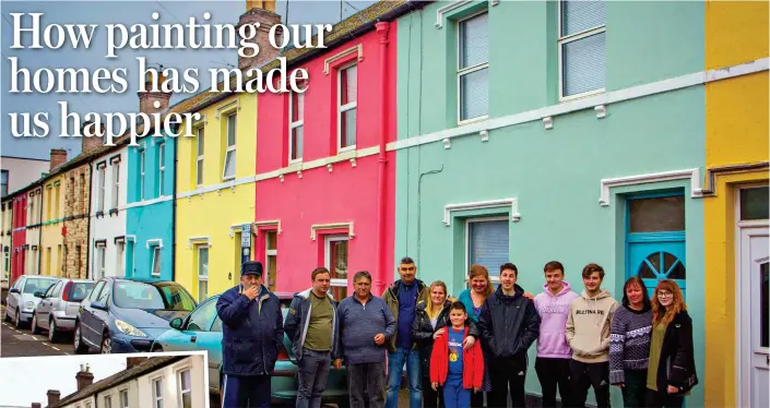  ??  ?? Brightened up: Neighbours standing outside the newly painted multicolou­red homes on Nettleton Road, Gloucester