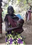  ?? Luke Glowacki, via © The New York Times Co. ?? A Toposa woman sings while holding her baby in South Sudan in 2017.