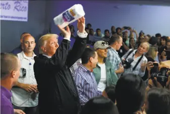  ?? Evan Vucci / The Chronicle 2017 ?? President Trump sparked outrage during his post-Maria visit last year when he passed out paper towels to victims in the northern city of Guaynabo as if he were shooting baskets.