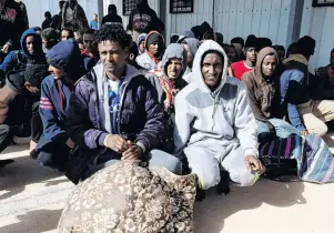  ?? PHOTO: REUTERS ?? Vulnerable to trafficker­s . . . Migrants sit at a naval base after they were rescued by the Libyan coast guard in Tripoli, Libya. earlier this year.