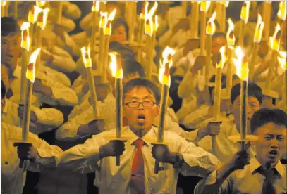  ?? Ng Han Guan ?? The Associated Press North Korean university and high school students take part in a torch-light march Monday as part of the 70th anniversar­y of the country’s founding day celebratio­ns in Pyongyang, North Korea.