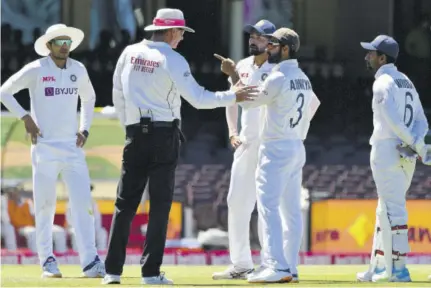  ?? (photo: afp) ?? India’s Captain Ajinkya Rahane (second right) and teammate Mohammed Siraj (third right) speak to the umpire as the game was halted after some remarks were allegedly made by spectators on the fourth day of the third cricket Test match between Australia and India at the Cricket and Sports Ground in Sydney on Sunday.