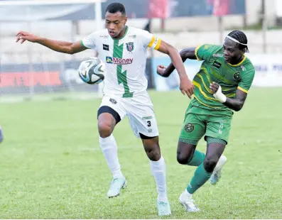  ?? RUDOLPH BROWN ?? Odean Pennycooke (left) of Tivoli Gardens shields the ball from Vere United’s Anthony Nelson during their Jamaica Premier League match at the Anthony Spaulding Sports Complex last night. Tivoli Gardens won 2-1.
