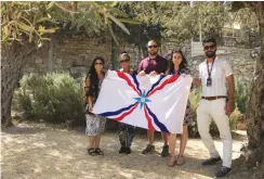  ?? (Courtesy) ?? PARTICIPAN­TS in the Assyrian youth trip to Israel organized by the Philos Leadership Institute hold an Assyrian flag.