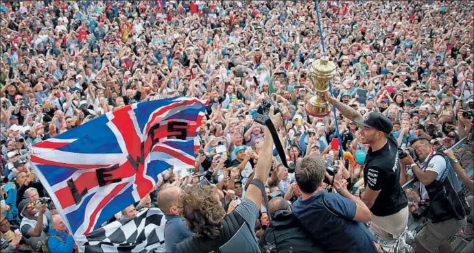  ?? CLIVE MASON / GETTY ?? La afición inglesa invadió la pista de Silverston­e, cuna del deporte de motor, para celebrar el quinto triunfo del año de Hamilton, que frena la remontada de Rosberg