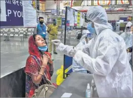  ?? PTI ?? A health worker collects a swab sample from a passenger at the Mumbai Central Railway Station on November 25.