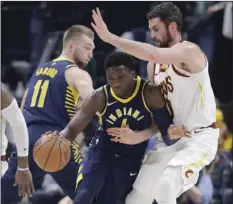  ??  ?? Indiana Pacers’ Victor Oladipo (center) is defended by Cleveland Cavaliers’ Kevin Love during the first half of an NBA basketball game Friday in Indianapol­is. AP PHOTO/DARRON CUMMINGS