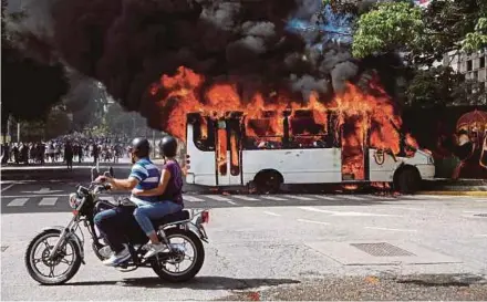  ?? REUTERS PIC ?? A bus burning near a protest against the Venezuelan government in Caracas on Saturday.