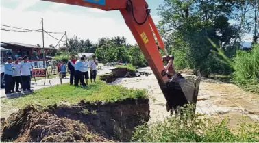  ??  ?? Safety measure: Excavators dredging the Pampang River in Keningau to prevent more erosion of the riverbank near populated areas.