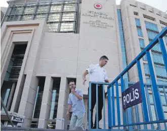  ?? LEFTERIS PITARAKIS, THE ASSOCIATED PRESS ?? A security guard adjusts barriers outside a court where the trial of journalist­s on charges of aiding terror groups was held, in Istanbul on Friday.