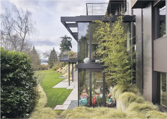 ?? PHOTOS BY BENJAMIN BENSCHNEID­ER, THE SEATTLE TIMES ?? Bigger, more efficient windows open to the backyard and Lake Washington on all three levels of this newly renovated 1961 home.