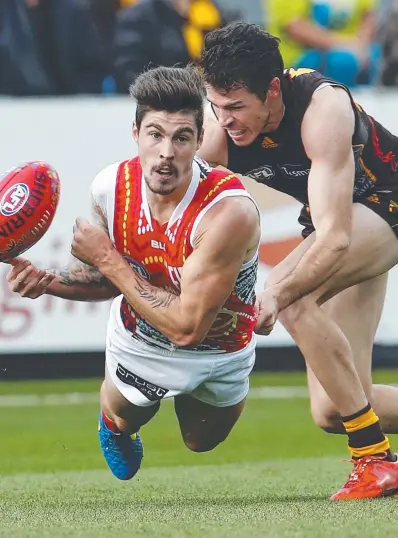  ?? Picture: MICHAEL KLEIN ?? INJURY DOUBT: Gold Coast Suns midfielder Alex Sexton fires a no-look handball as Hawk Isaac Smith moves in on Saturday but he may miss the AFL Round 10 Swans clash as a result of a groin strain.